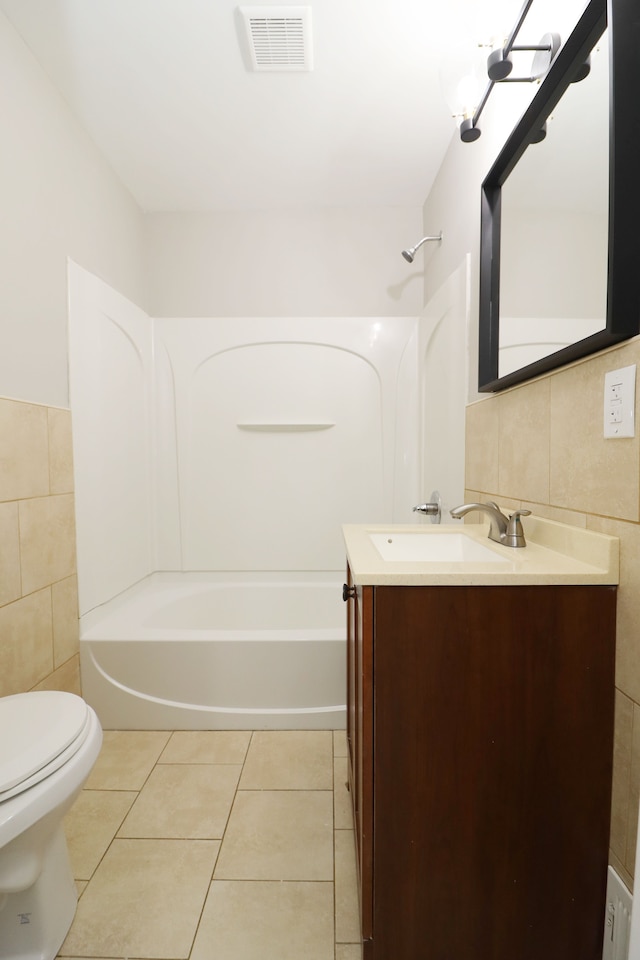 full bathroom with vanity, tile patterned flooring, toilet, tile walls, and tub / shower combination