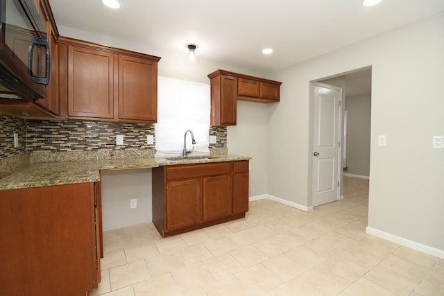 kitchen with light stone countertops, tasteful backsplash, light tile patterned flooring, and sink