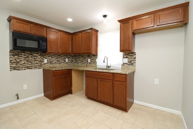 kitchen with light stone countertops, light tile patterned floors, backsplash, and sink