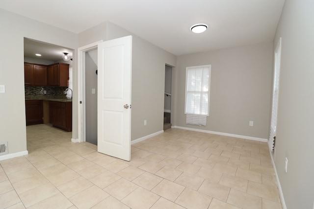 tiled empty room featuring sink