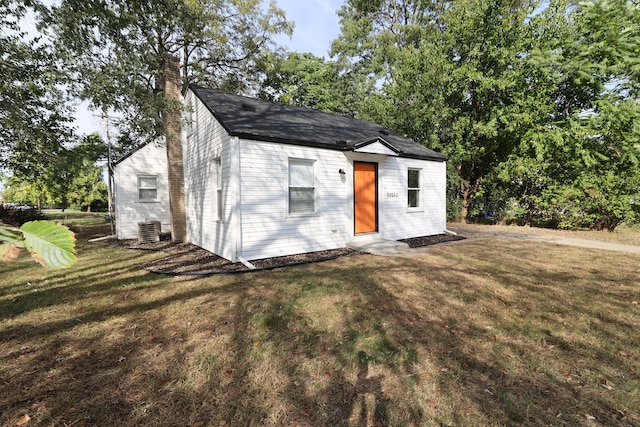 view of front of property with a front yard and central air condition unit