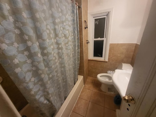 7603 Kentucky St, Dearborn, MI 48126 - bathroom featuring toilet, tile walls, tile patterned floors, a wainscoted wall, and shower / tub combo with curtain