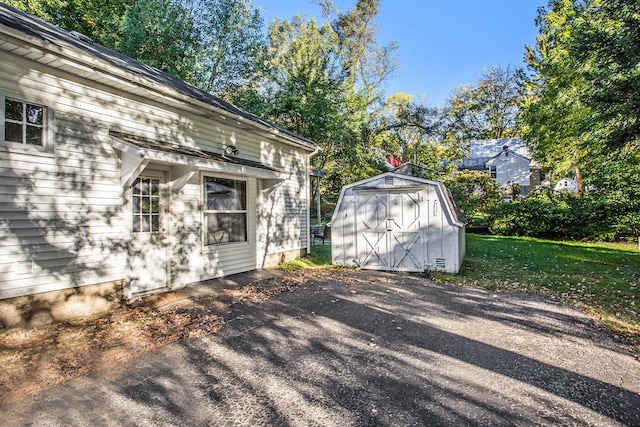 view of home's exterior with a lawn and a shed