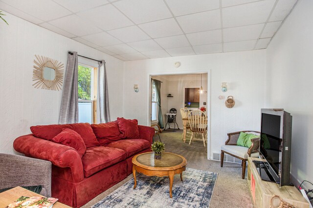 carpeted living room with a paneled ceiling