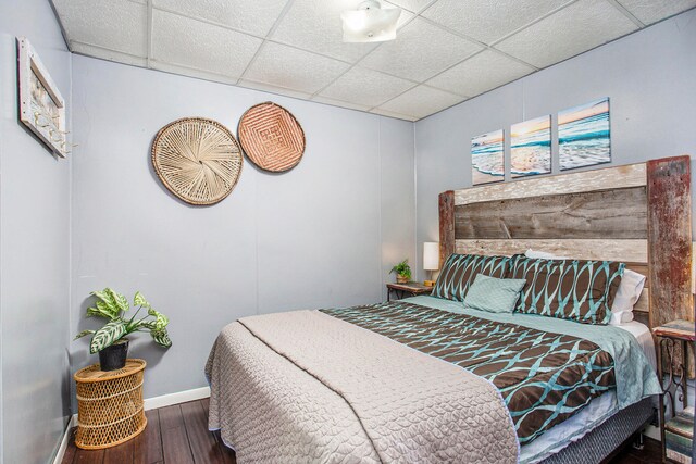 bedroom featuring a paneled ceiling and hardwood / wood-style floors