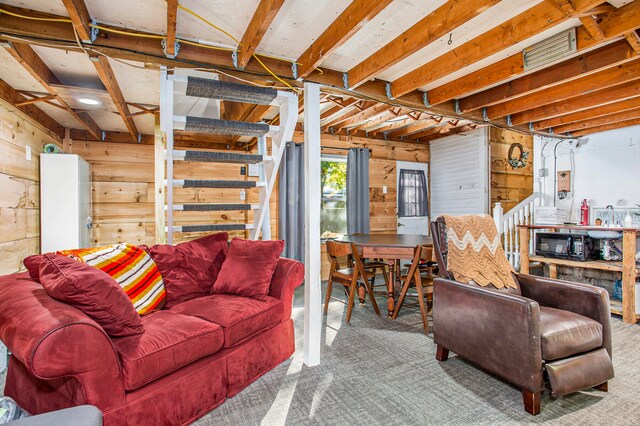 carpeted living room with wood walls