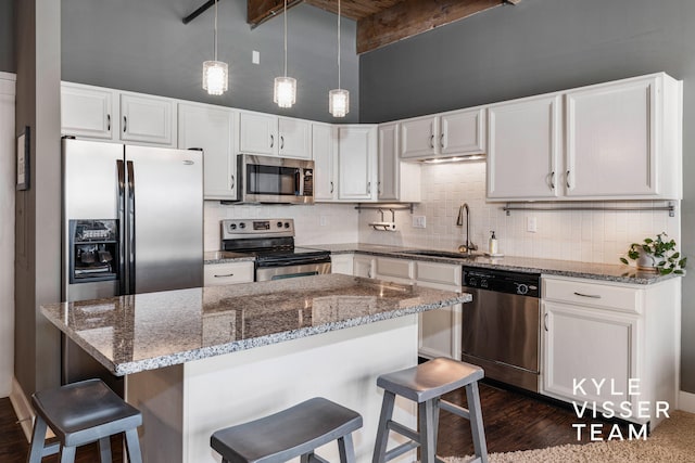 kitchen with sink, dark wood-type flooring, beamed ceiling, white cabinets, and appliances with stainless steel finishes