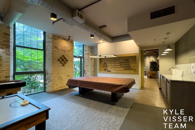 recreation room featuring sink, brick wall, light wood-type flooring, and billiards