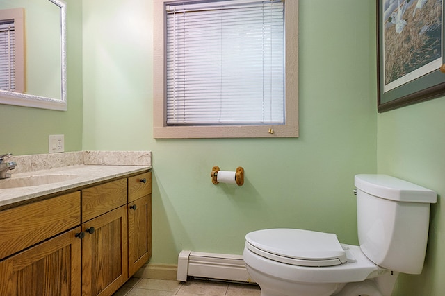 bathroom featuring tile patterned floors, a wealth of natural light, vanity, baseboard heating, and toilet