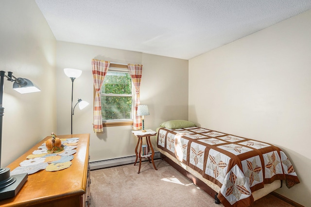 carpeted bedroom featuring a textured ceiling and a baseboard heating unit