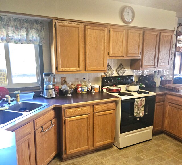 kitchen with decorative backsplash, sink, and white electric range oven