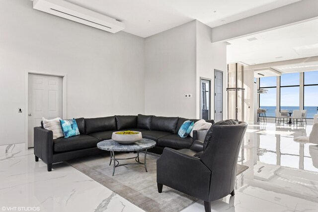 639 Sul Lago Ave S, Benton Harbor, MI 49022 - living room featuring a wall mounted AC, light marble finish floors, floor to ceiling windows, a water view, and a towering ceiling