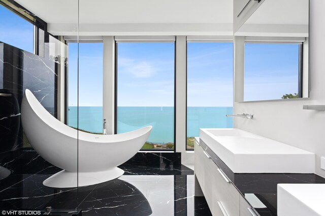639 Sul Lago Ave S, Benton Harbor, MI 49022 - bathroom featuring a soaking tub, healthy amount of natural light, and marble tiled floors