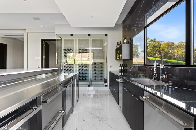 639 Sul Lago Ave S, Benton Harbor, MI 49022 - kitchen featuring stainless steel dishwasher, modern cabinets, a sink, dark cabinets, and light marble finish flooring