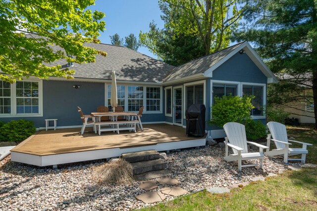 rear view of property with a sunroom and a wooden deck