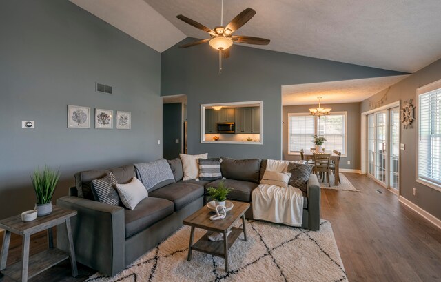 living room with hardwood / wood-style floors, ceiling fan with notable chandelier, a textured ceiling, and a wealth of natural light