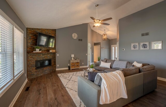 living room with ceiling fan, a fireplace, dark wood-type flooring, and vaulted ceiling