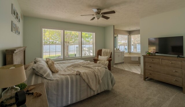 bedroom with ceiling fan, light colored carpet, and a textured ceiling