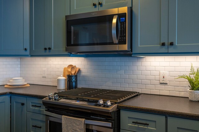 kitchen with blue cabinetry, decorative backsplash, and appliances with stainless steel finishes