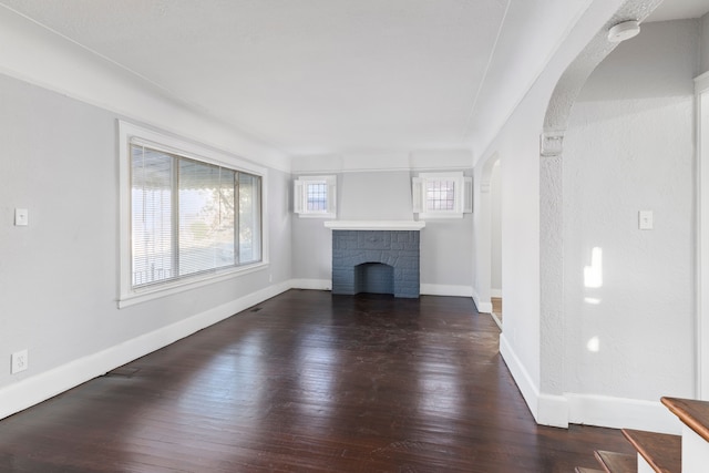 unfurnished living room with a fireplace and dark wood-type flooring