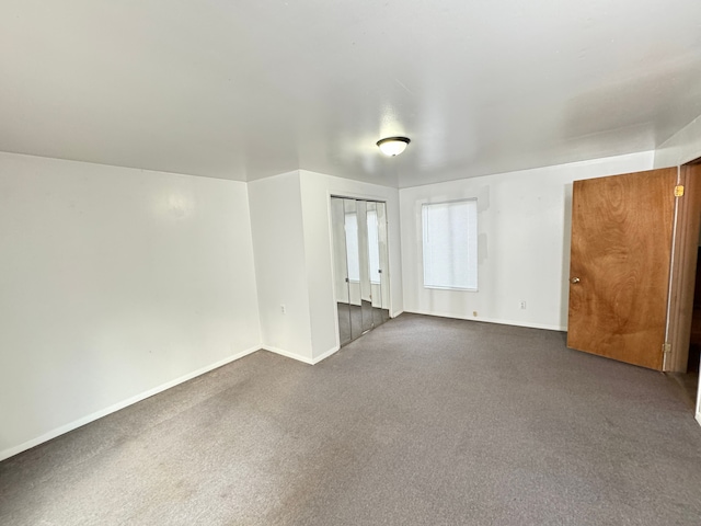 spare room with dark colored carpet