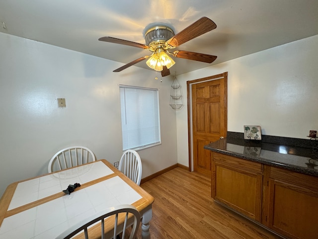 dining space with light wood-type flooring and ceiling fan