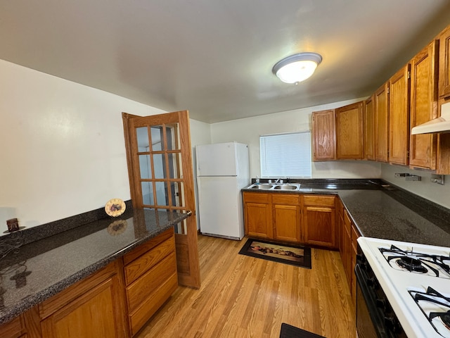 kitchen featuring white appliances, light hardwood / wood-style flooring, custom exhaust hood, and sink