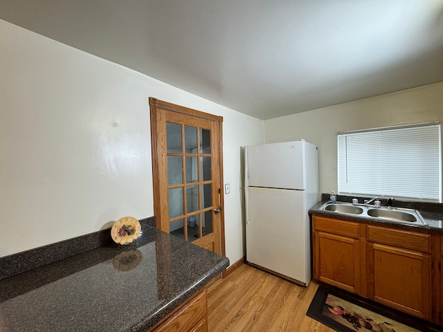 kitchen with light hardwood / wood-style flooring, white fridge, and sink