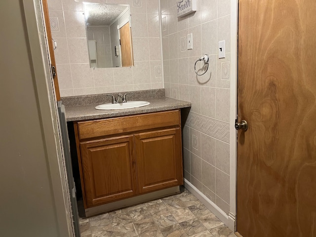 bathroom featuring vanity and tile walls