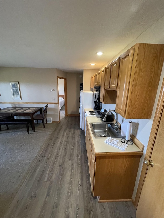 737 Maplewood Ln, Kewadin, MI 49648 - kitchen featuring a sink, wood finished floors, baseboards, black microwave, and light countertops