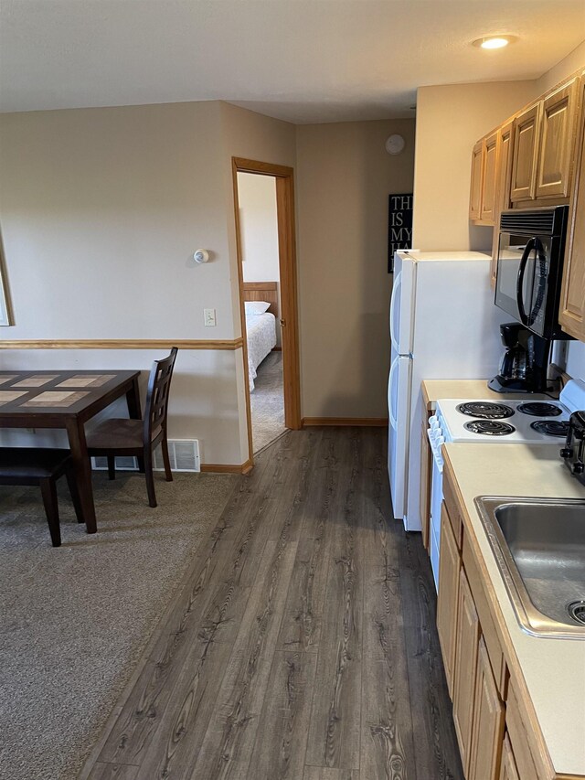 737 Maplewood Ln, Kewadin, MI 49648 - kitchen featuring black microwave, dark wood-type flooring, a sink, light countertops, and electric stove