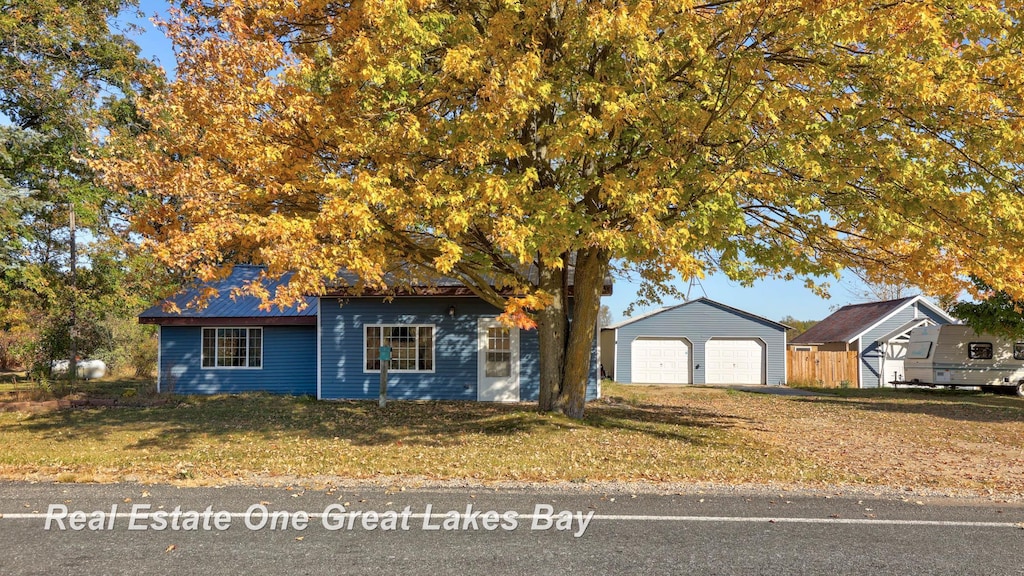 view of front of home featuring an outbuilding, a garage, and a front lawn