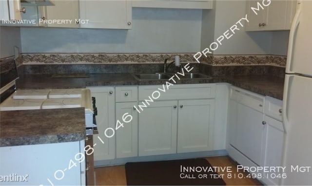 kitchen featuring white cabinetry, sink, white appliances, and hardwood / wood-style flooring