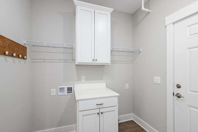 laundry area featuring cabinets, washer hookup, and dark hardwood / wood-style floors