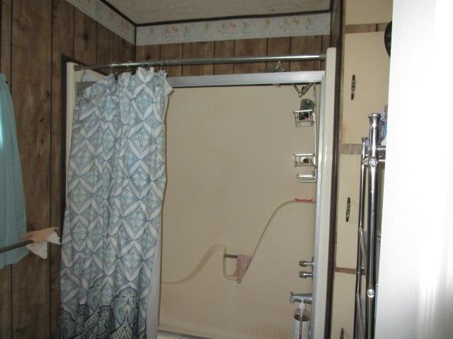 bathroom featuring wood walls