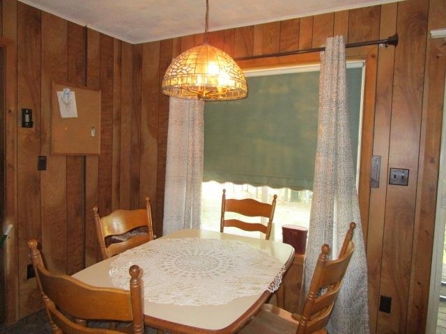 dining area featuring wooden walls