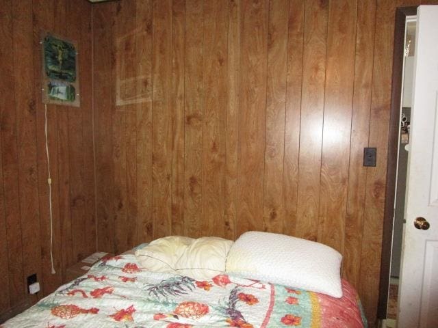 bedroom featuring wooden walls