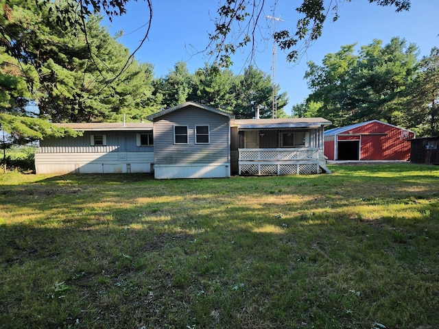 back of house featuring a yard and an outdoor structure