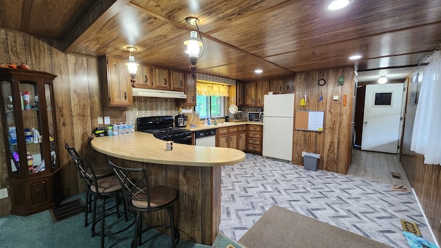 kitchen featuring kitchen peninsula, wood walls, light hardwood / wood-style floors, white appliances, and wood ceiling