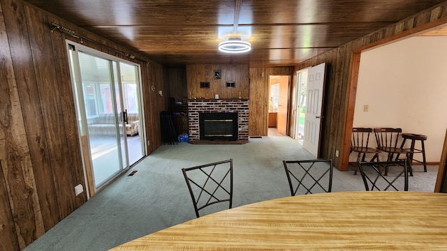 interior space featuring wood walls, wood ceiling, and a brick fireplace