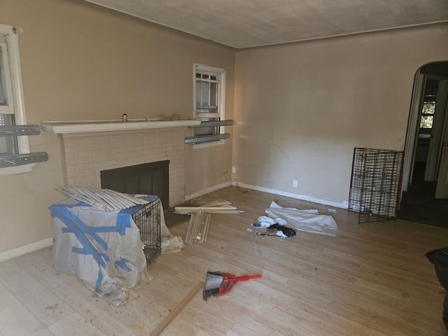 living room with wood-type flooring and a brick fireplace