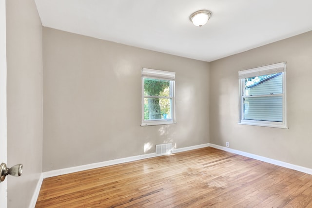 empty room with light hardwood / wood-style flooring and a healthy amount of sunlight