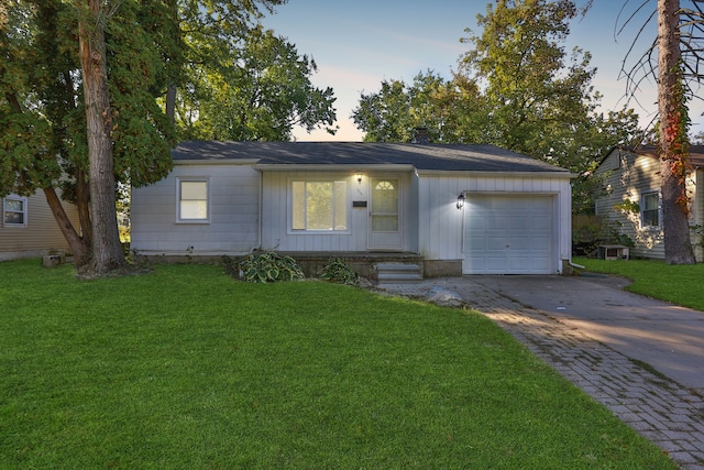 ranch-style home with a yard and a garage