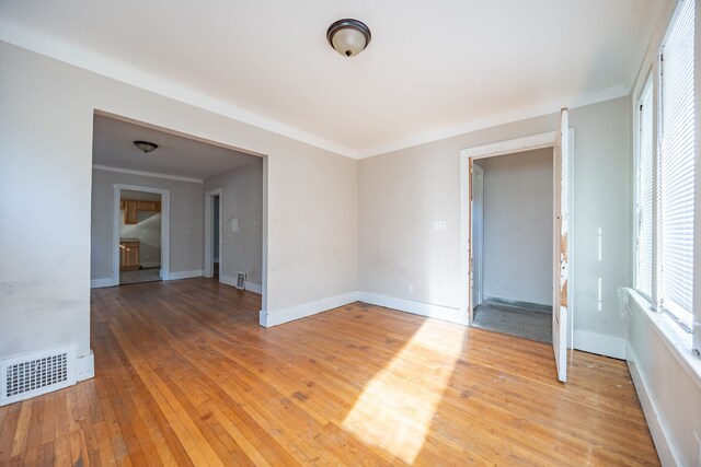 empty room featuring hardwood / wood-style floors and ornamental molding