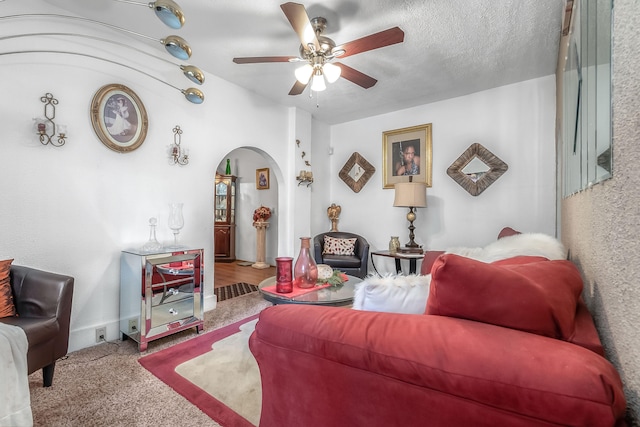 living room with carpet, ceiling fan, and a textured ceiling