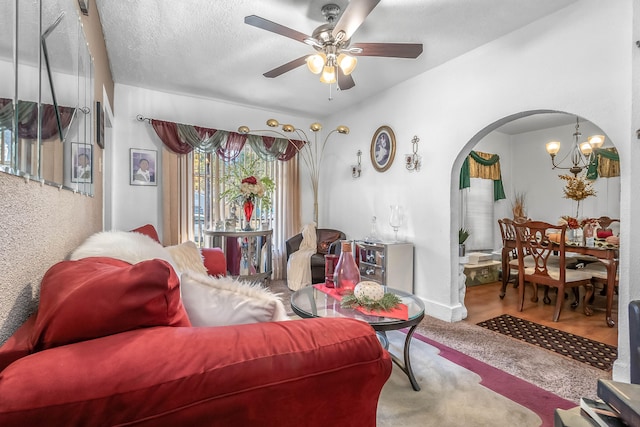 living room with a textured ceiling and ceiling fan with notable chandelier