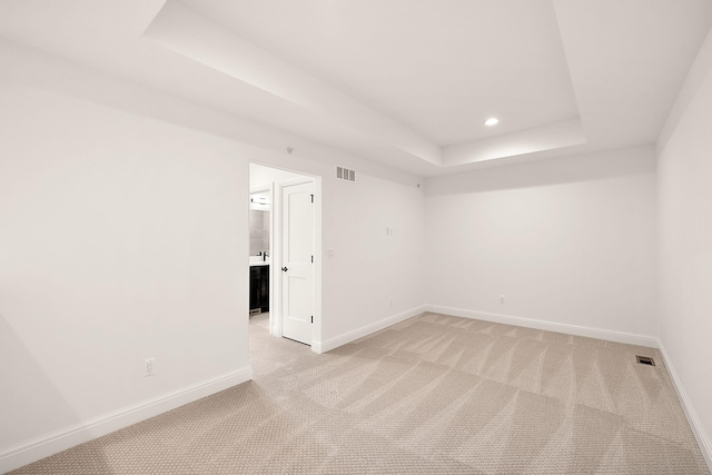carpeted spare room with a tray ceiling