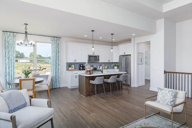 kitchen featuring white cabinetry, pendant lighting, an island with sink, and stainless steel appliances