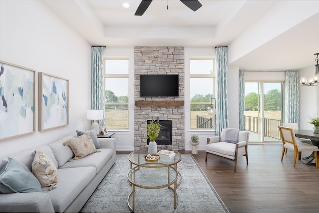 living room featuring hardwood / wood-style floors, a raised ceiling, a fireplace, and a wealth of natural light