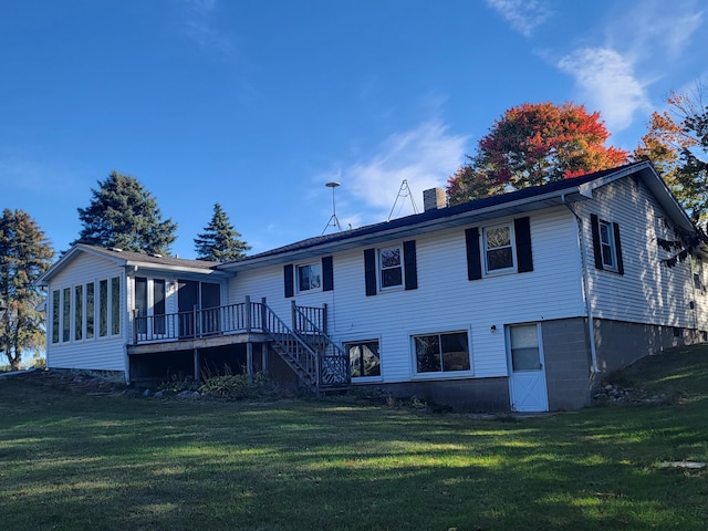 rear view of house with a deck, a chimney, stairs, and a yard